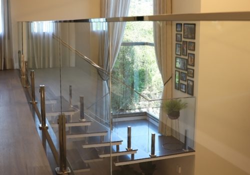 GUARDA-CORPO DE VIDRO COM PINÇAS E ACABAMENTO SUPERIOR EM AÇO INOX